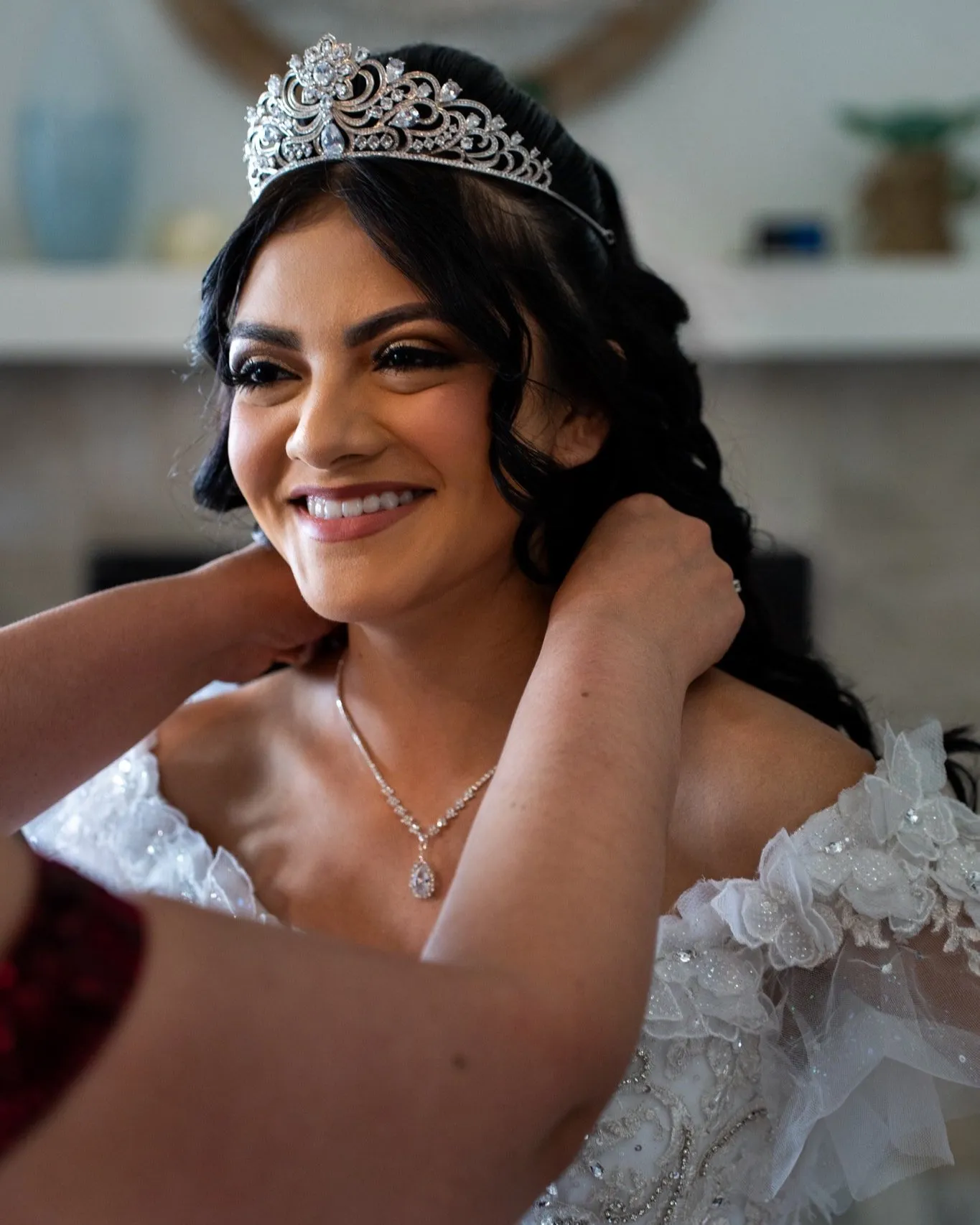 Mother helping daughter get ready during quince day prep